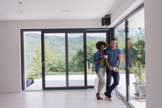 romantic happy young multiethnic couple enjoying morning coffee by the window in their luxury home