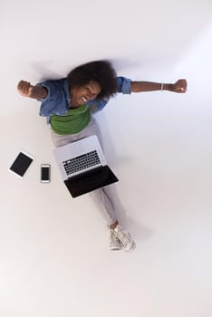 Portrait of happy young african american woman sitting on floor with laptop top view