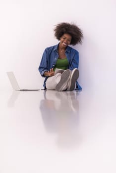 Portrait of happy young african american woman sitting on floor with laptop