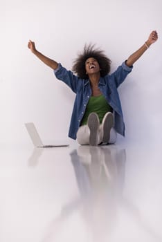 Portrait of happy young african american woman sitting on floor with laptop