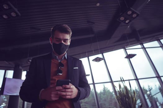business man wearing coronavirus  protective  medical face mask while using smartphone and new normal smart  technology