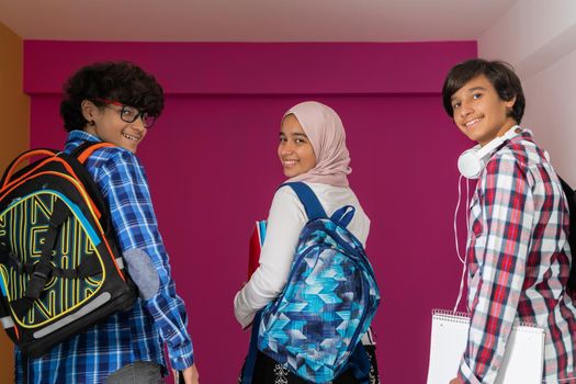 A group of Arab teenagers, a student team walking forward into the future and back to school the concept of a pink background. The concept of successful education for young people. Selective focus. High quality photo