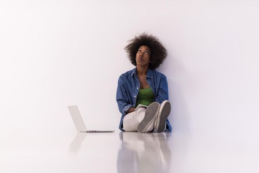 Portrait of happy young african american woman sitting on floor with laptop