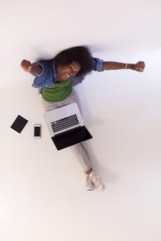 Portrait of happy young african american woman sitting on floor with laptop top view