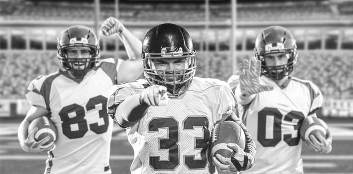 Portrait of American football player pointing against gray background