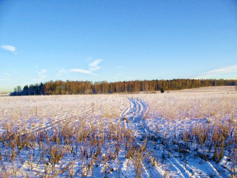 The snow-covered road is an early, sunny, frosty morning in the suburbs.