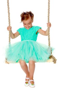 Beautiful little girl swinging on swing. The concept of family happiness, child development, sports education and summer recreation. Isolated on white background.