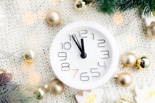 A clock on the beach with a garland . A white watch. Cozy vibes . Home comfort. New Year and Christmas. Decorating