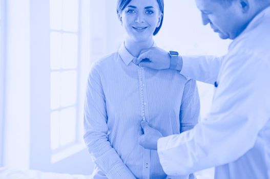 Doctor showing young patient her chest in his office at the hospital.