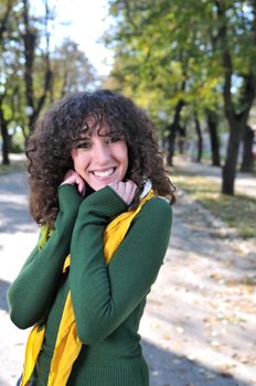 brunette Cute young woman with colorful scarf smiling outdoors in nature
