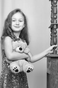 Little girl near the beautiful old bedside table. Photo in vintage style.