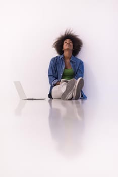 Portrait of happy young african american woman sitting on floor with laptop