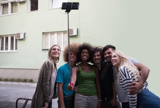 Multiethnic Group of friends taking picture of themselves with smartphone