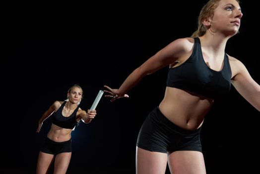 woman athletic runners passing baton in relay race