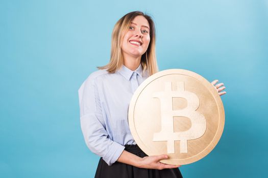 woman holding a big Golden Bitcoin. virtual money.