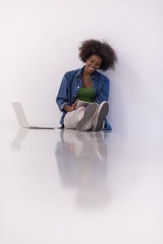 Portrait of happy young african american woman sitting on floor with laptop