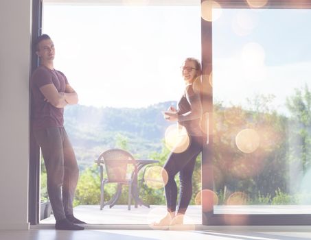 young beautiful handsome couple enjoying morning coffee and breakfast on the door of their luxury home villa