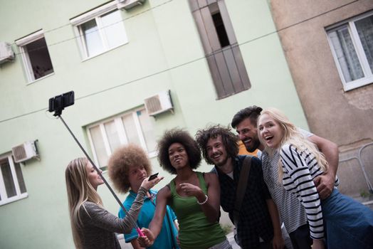 Multiethnic Group of friends taking picture of themselves with smartphone