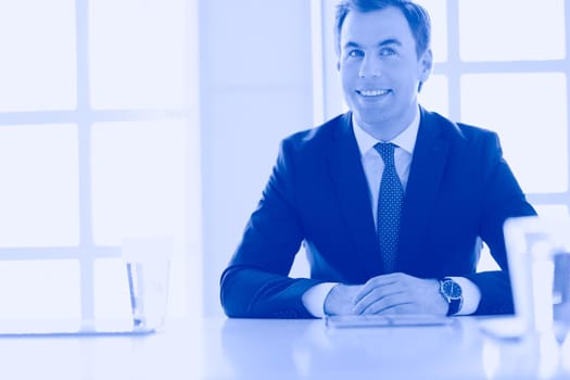 Portrait of young man sitting at his desk in the office