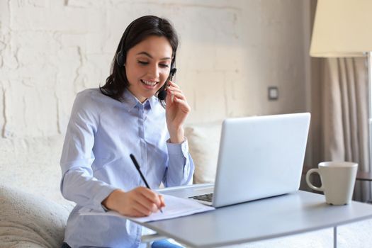 Freelance operator talking with headsets and consulting clients from home office