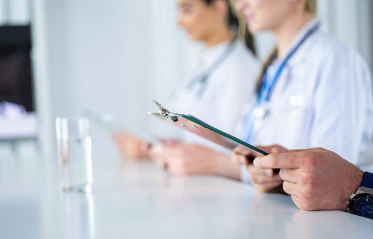 Doctors at the meeting, sitting on the desk.