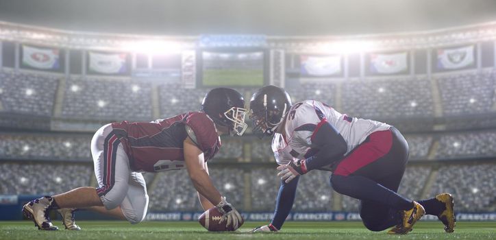 american football players are ready to start a match on modern field at night