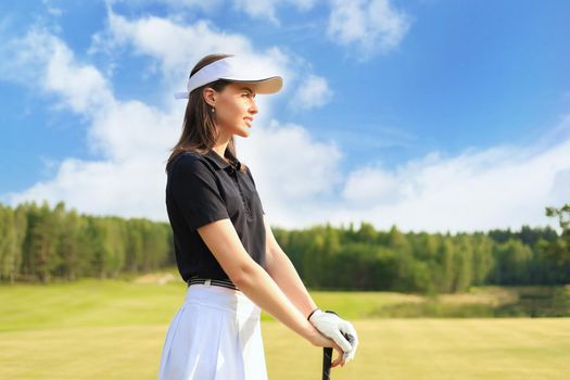 Woman golfer hits an fairway shot towards the club house