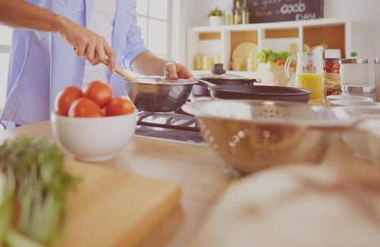 Man preparing delicious and healthy food in the home kitchen.