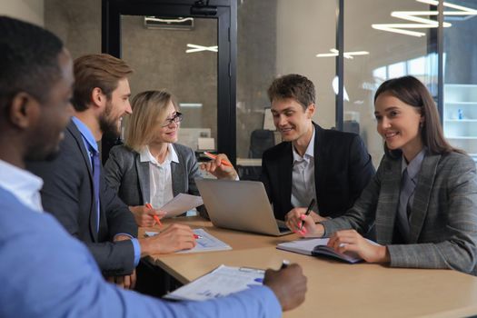 Group of happy young business people in a meeting at office