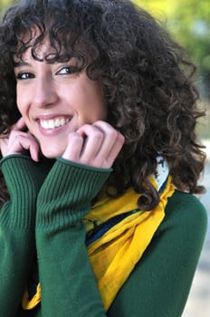 Young curly woman smiling outdoors in nature