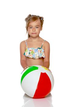 A little girl in a swimsuit is playing with a big ball. The concept of a family vacation at sea, happy childhood.Isolated on white background.