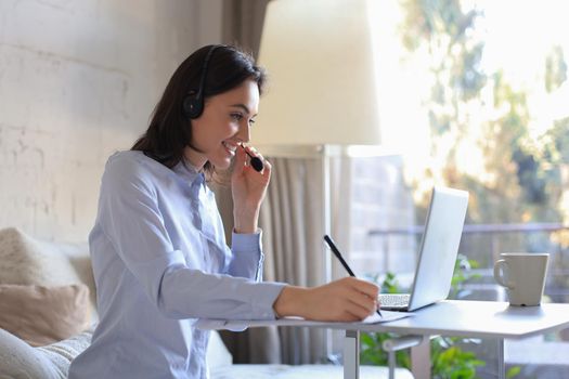 Freelance operator talking with headsets and consulting clients from home office
