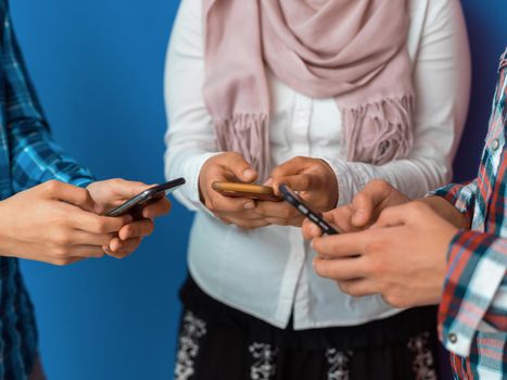 Arab teenagers group using smartphones for social media networking and sharing information for online education. High quality photo. Selective focus 