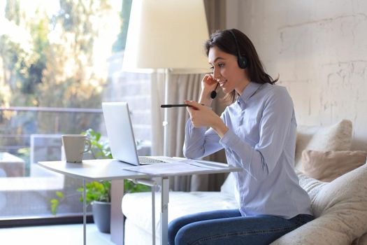 Freelance operator talking with headsets and consulting clients from home office