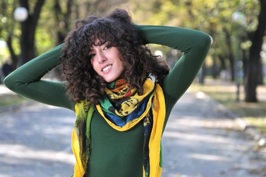 brunette Cute young woman with colorful scarf smiling outdoors in nature
