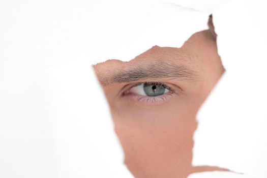 close up. businessman looking through a hole in the paper wall.photo with copy space