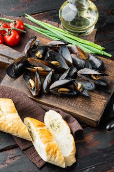 Baked Mussels with ingredient, on wooden cutting board, on old dark wooden table background