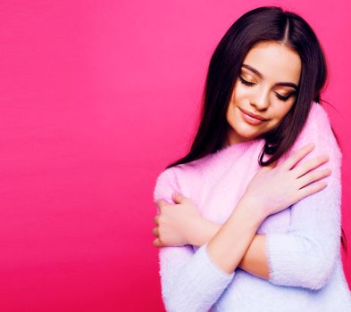 young pretty girl with brunette long hair posing cheerful on pink background, lifestyle people concept close up