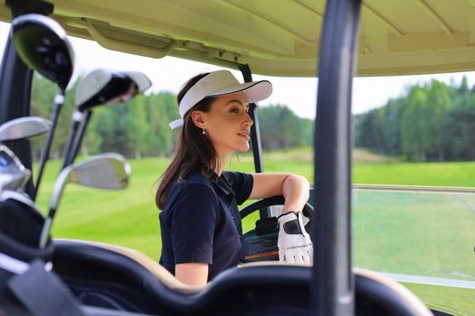 Beautiful cheerful woman driving golf cart