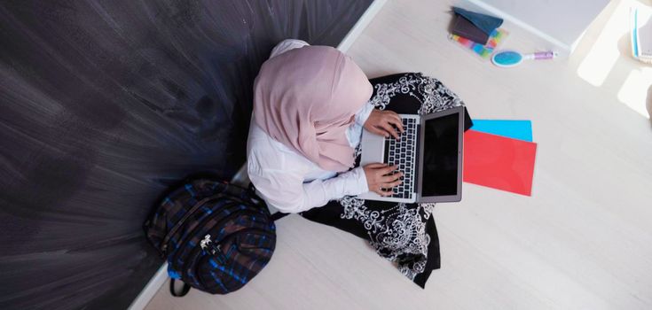 arab female student working on laptop from home  top view