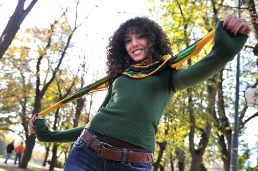 brunette Cute young woman with colorful scarf smiling outdoors in nature
