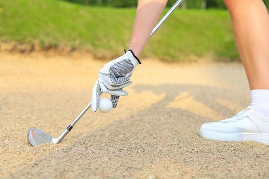 Hand putting golf ball on tee in golf course