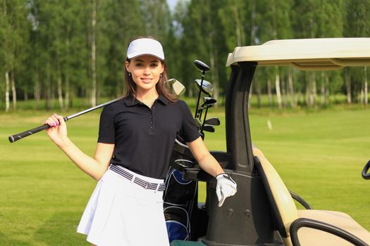 Beautiful cheerful woman standing near in golf cart
