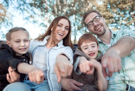 close up.smiling family pointing at you.the concept of family leisure