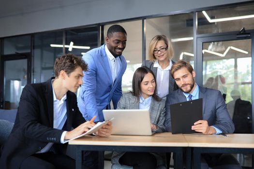 Group of happy young business people in a meeting at office