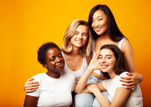 diverse multi nation girls group, teenage friends company cheerful having fun, happy smiling, cute posing on yellow background, lifestyle people concept, african-american, asian and caucasian close up