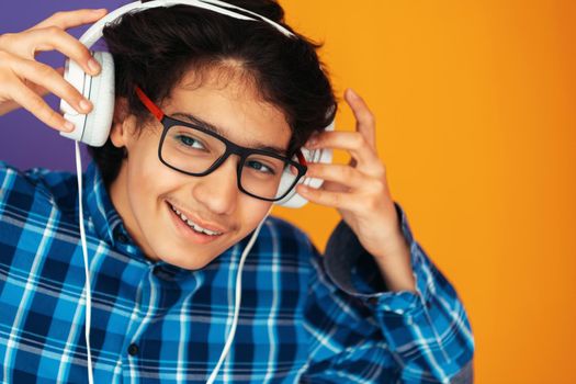 Teenage Boy Wearing Headphones And Listening To Music purple background. High quality photo