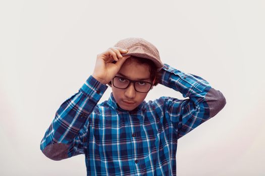 portrait of smart-looking Arab teenager with glasses wearing a hat in casual school look isolated on white copy space. High quality photo