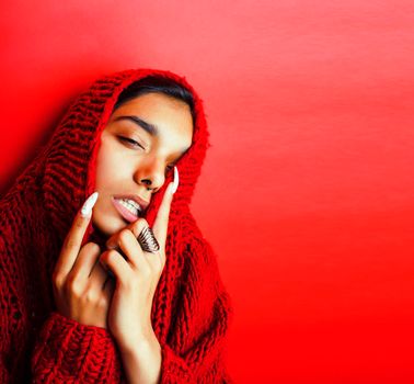 young pretty indian girl in red sweater posing emotional, fashion hipster teenage, lifestyle people concept closeup