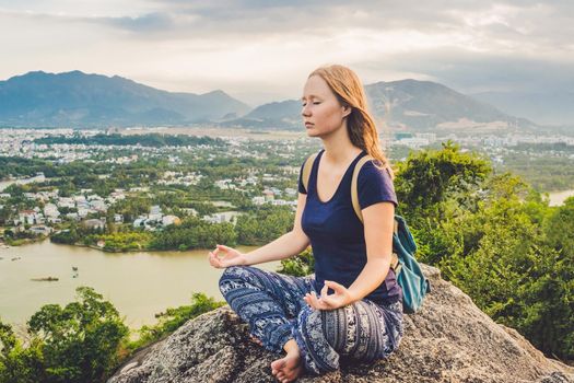 Young woman meditating over ancient city landscape on sunrise Copy space.